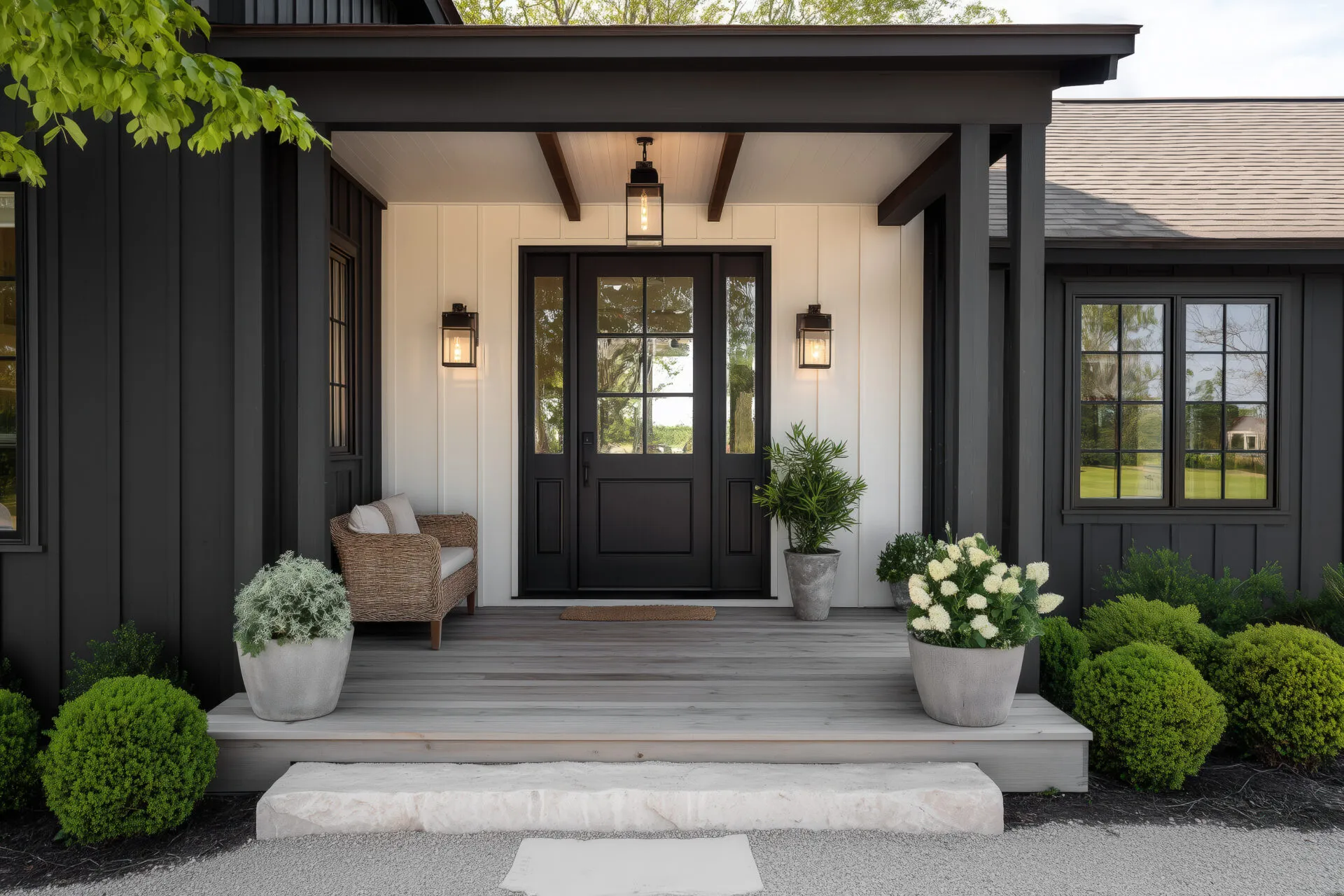 Black entry door with sidelites on a covered front porch