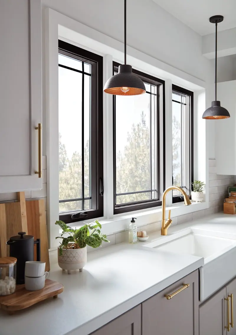 Black casement windows over a white kitchen sink