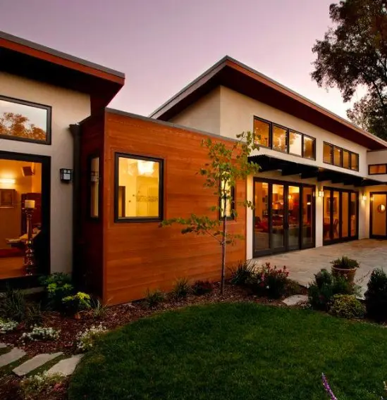 Modern home with black windows and patio doors at dusk