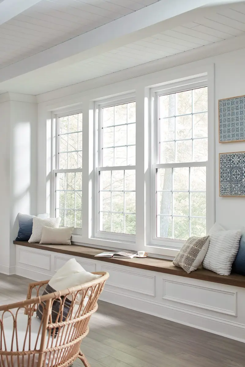 Three white double-hung windows above a window seat